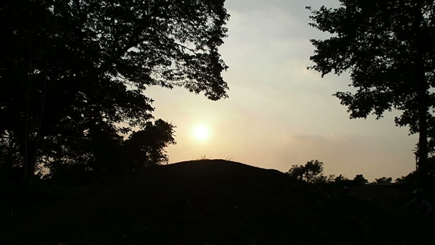 Childrens cycling,Ride up the mound Between two large trees and the sun shines down.Concept Silhouette stay.