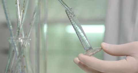 Close Up of Glass Bottle Scientist Adding Test Liquid Micro Pipette Laboratory