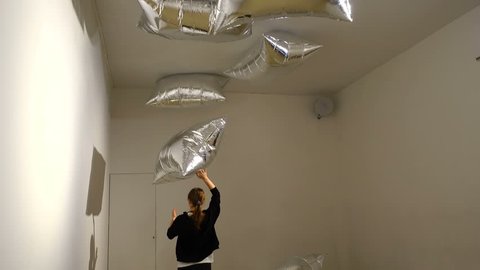 MADRID, SPAIN - APRIL 05, 2018: A girl playing with "silver clouds" in the CaixaForum Madrid at the exibition Andy Warhol "Warhol. Mechanical Art."