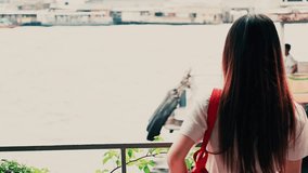 Full video HD summer travel and landscape concept from backside of long black hair asian girl stand and see to river at side of port with sky and river background