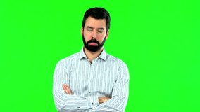 Handsome man with beard with sad and depressed expression. Serious gesture on green screen chroma key