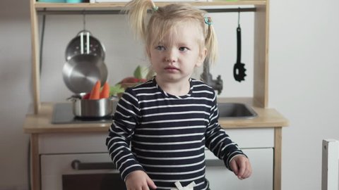 Cute little girl jumping in the kitchen