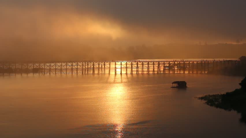 The vast river have is a long wooden bridge and floating house under the bridge In the morning there is sunshine Beautiful Contrast.