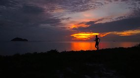 Tracking shot of woman silhouette jogging on the beach after sunset time.Fitness sport girl jogging fast training cardio near sea. Fly cam slow motion video