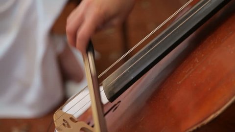 Close up of female hand playing cello with cello bow. Cello playing music background