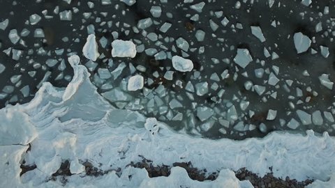 Moving blocks of ice in a winter sea forming a beautiful space-like pattern (4k drone video)