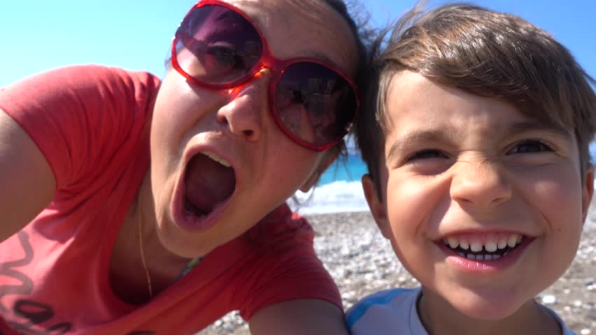4K Selfie of funny mother and son near the azure sea
