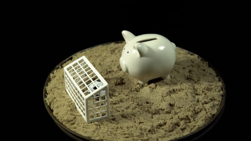 A white piggy bank stands sand in front of a miniature football ball, which is in the gate. The composition rotates on a black background, seamless loop shooting, 4K.