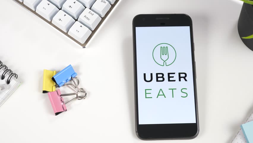 Smartphone showing uber eats logo on its screen with camera panning.