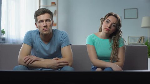 Couple in conflict watching tv silently ignoring each other, relationship crisis