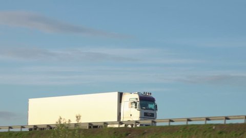 Cargo truck travel on inter city highways. International cargo transportation. Truck car drives through the bridge.