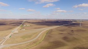 Aerial video of  wind turbine farm next to highway