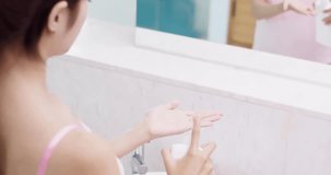 beauty woman apply lotion on her hand in the bathroom