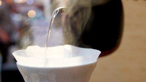 Advertising, Business, Beverage, Lifestyle Concept - Barista pouring water on coffee ground with filter, Hand drip coffee. の動画素材