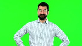 Handsome man with beard posing with arms at hip on green screen chroma key