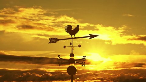 Weathervane cockerel floating against sunset
