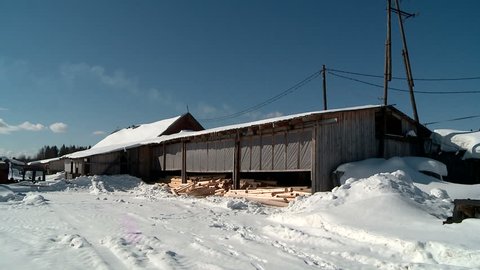 the mill in winter produces logs for Russian hut