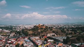 Aerial footage of church built on top of a pyramid by the Spanish in Cholula, Puebla. You can see the base of the pyramid, the church and the city in the background.