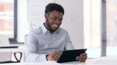 business, people and technology concept - african american businessman with tablet pc computer at office