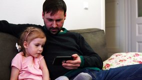 Daughter clicks on the smartphone screen that holds the father