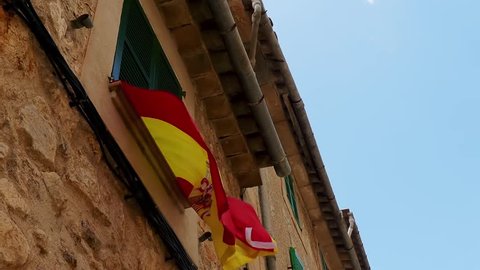 Flag of Spain (Bandera de Espana, la Rojigualda) on background of old city house.