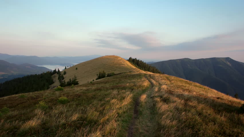 POV walking on fall path to woods, valley and mounts at sunset with beautiful clouds. Sunny autumn day Hiking in colorful red meadow wild nature mountain outdoors. 4k point of view establishing video