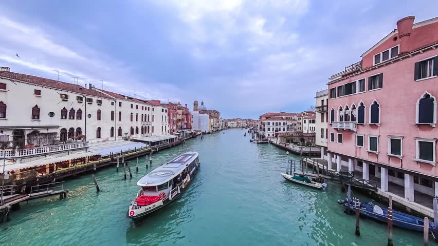 Gondolas and boats traffic in Venice timelapse, Grand Canal panoramic view. Boat station. Blue cloudy sky at summer day