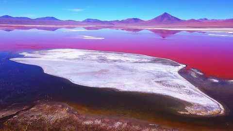 Laguna Colorada with vivid orange water and salt islets aerial shot. Altiplano, Bolivia