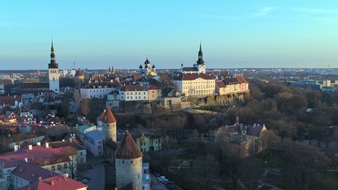 Aerial approaching fortified Toompea hill and the Estonian government building over Tallinn old town walls during beautiful sunset
