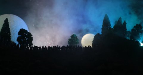 Silhouette of a large crowd of people in forest at night watching at rising big full Moon. Decorated background with night sky with stars, moon and space elements. Selective focus. Surreal world