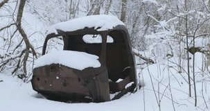 old and rusty car body in the forest in winter