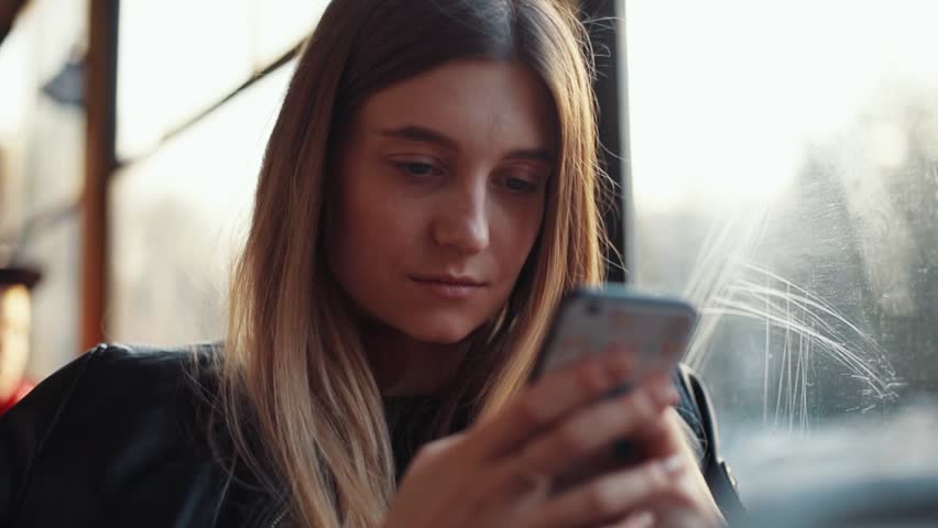 Portrait of attractive smiling girl in train using smartphone chatting with friends woman hand internet technology cellphone city mobile phone smartphone tram female transport young slow motion Royalty-Free Stock Footage #1010483681