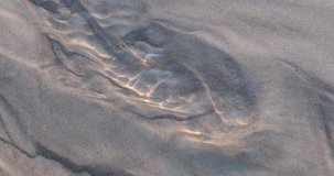 Water flows through the sand leaving beautiful patterns