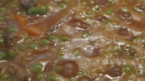 Cooking of stew with pork meat and peas 4K footage