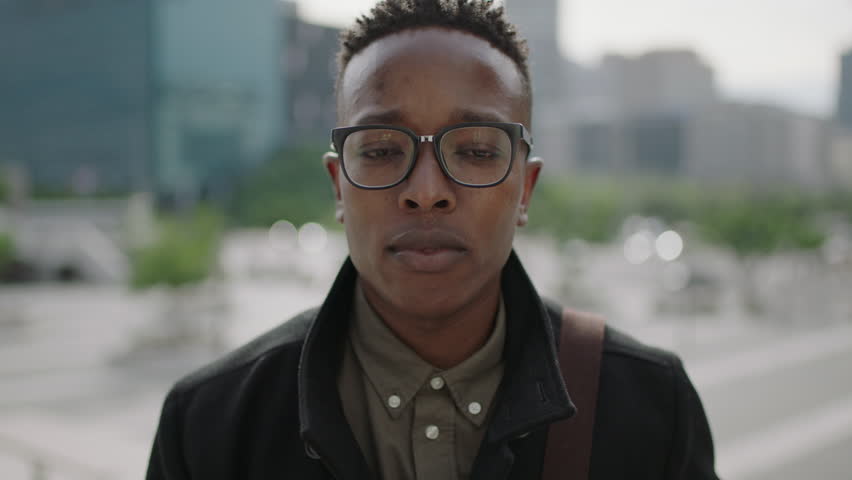 close up portrait of young trendy african american man student wearing stylish fashion glasses getting ready in urban city background real peoples series