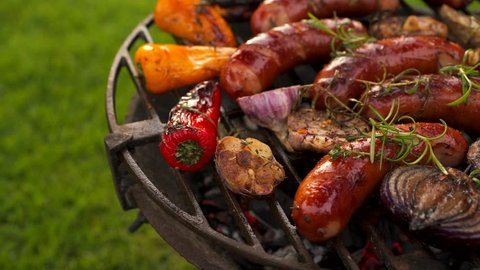 Grilled sausages and vegetables on a grilled plate, outdoor. Grilled food, bbq, 4K