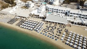 Aerial drone bird's eye view video of iconic paradise organised beach of Ornos in island of Mykonos, Cyclades, Greece