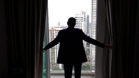 Businessman unveil curtains and admire view on balcony, super slow motion 240fps
