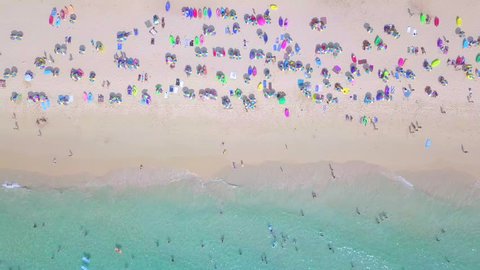 Top view crowd people in Surin Beach in Andaman sea, Phuket, Southern beach of Thailand, Surin beach is a very famous tourist destination in Phuket, Aerial view beautiful beach from flying drone, 4k