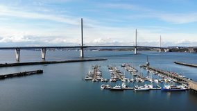 Aerial drone footage of Queensferry Crossing bridges over Firth of Forth bay, Scotland, United Kingdom. 