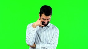 Handsome man with beard making phone gesture and speaking with someone. Call me back sign on green screen chroma key