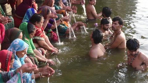 Varanasi / India 27 March 2018 Unidentified women and men taking ritual bath in the river Ganga at Varanasi  Uttar Pradesh India