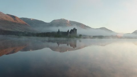 Incredible aerial drone shot of Kilchurn Castle with low mist, Scotland