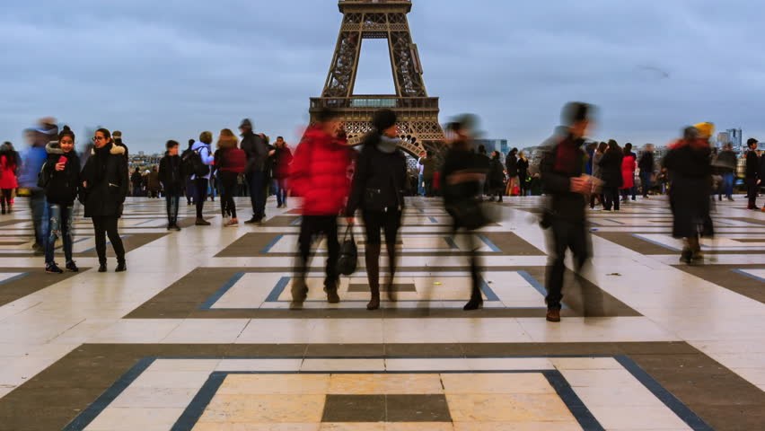 Tilt Time lapse. People walking at the square Trocadero near the Eiffel tower. Iconic symbol of Paris, famous historical landmark in France. Popular romantic places. Tourism and travel concept