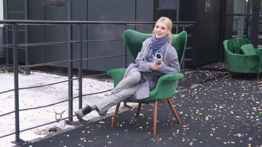 Street photo shoot of a girl in a coat. Photoshoot for the catalog of a coat. Portrait on a black background. Model posing on camera.