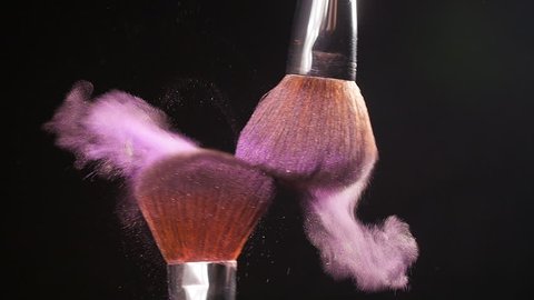 Powderbrush on black background with pink powder
