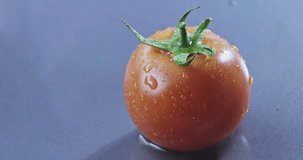 Red ripe juicy tomato falls into water and rolls. Slow motion 2k video shooted on 240 fps