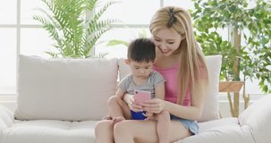 mommy use phone with son on sofa at home