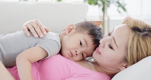 son lying on mother body at home