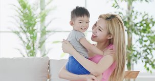 mommy hug her son and sit on sofa at home